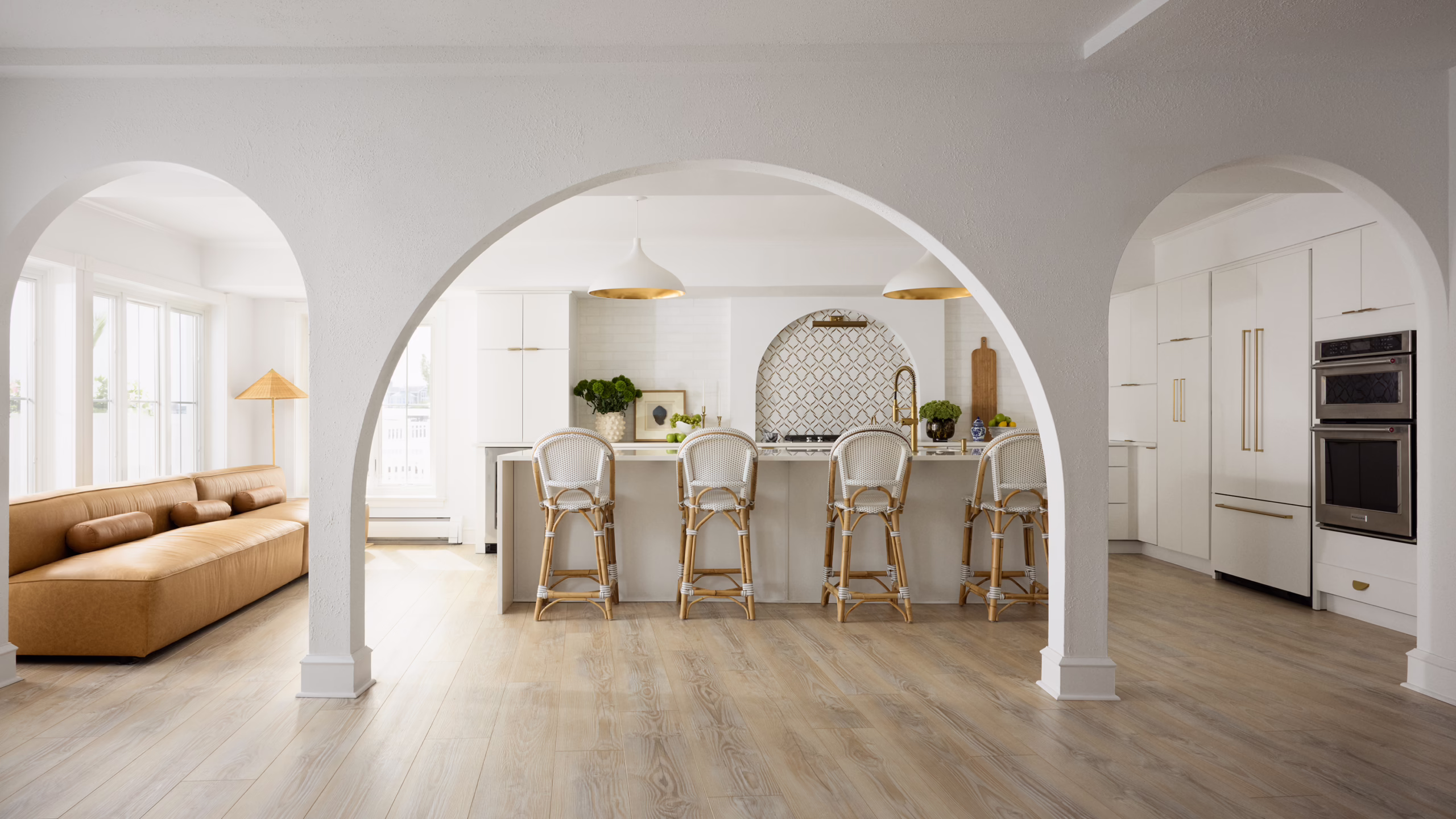 Bayshore open plan interior with arched openings, a kitchen island and tan banquette
