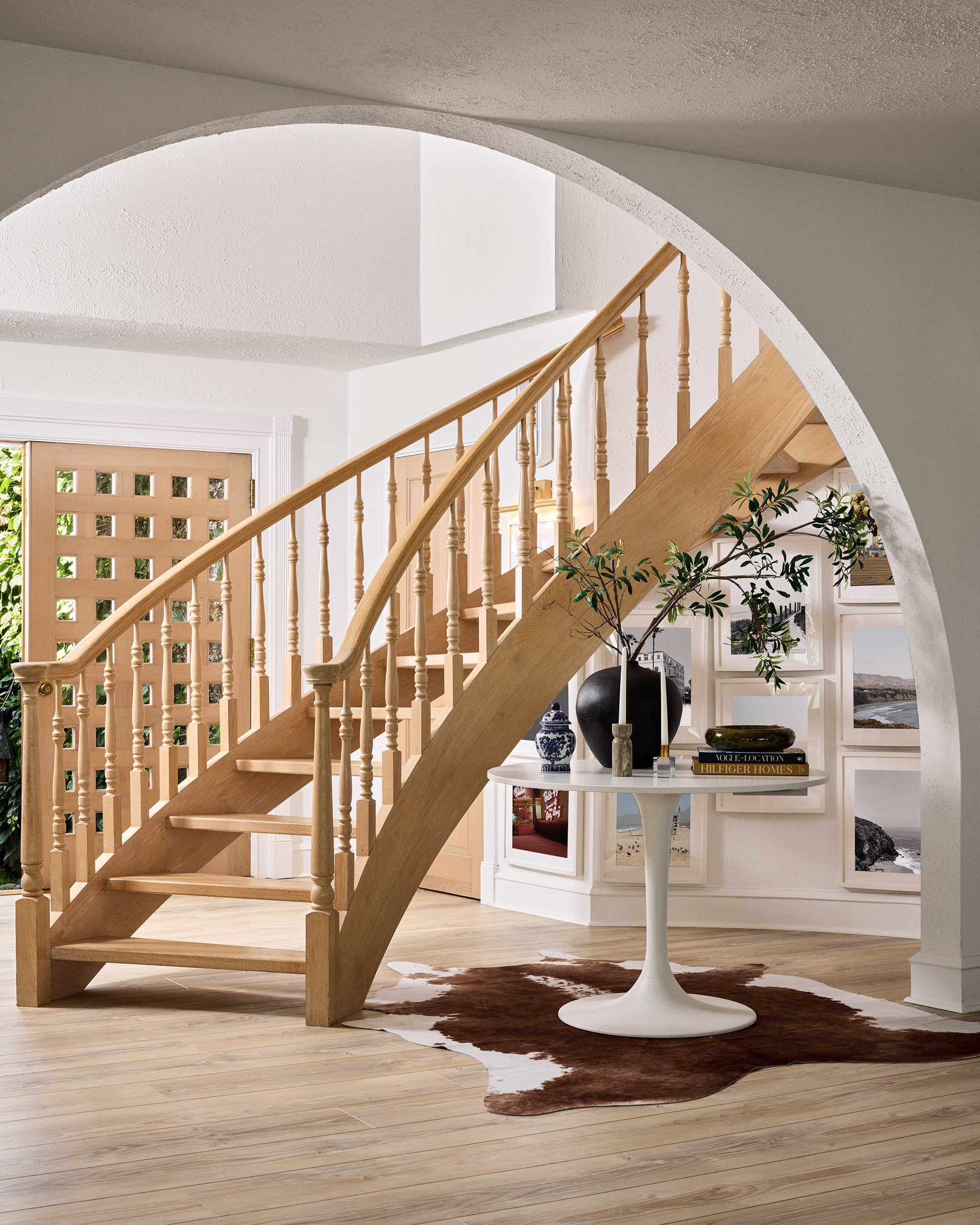 Curved wood staircase beneath an interior arch in the Bayshore home