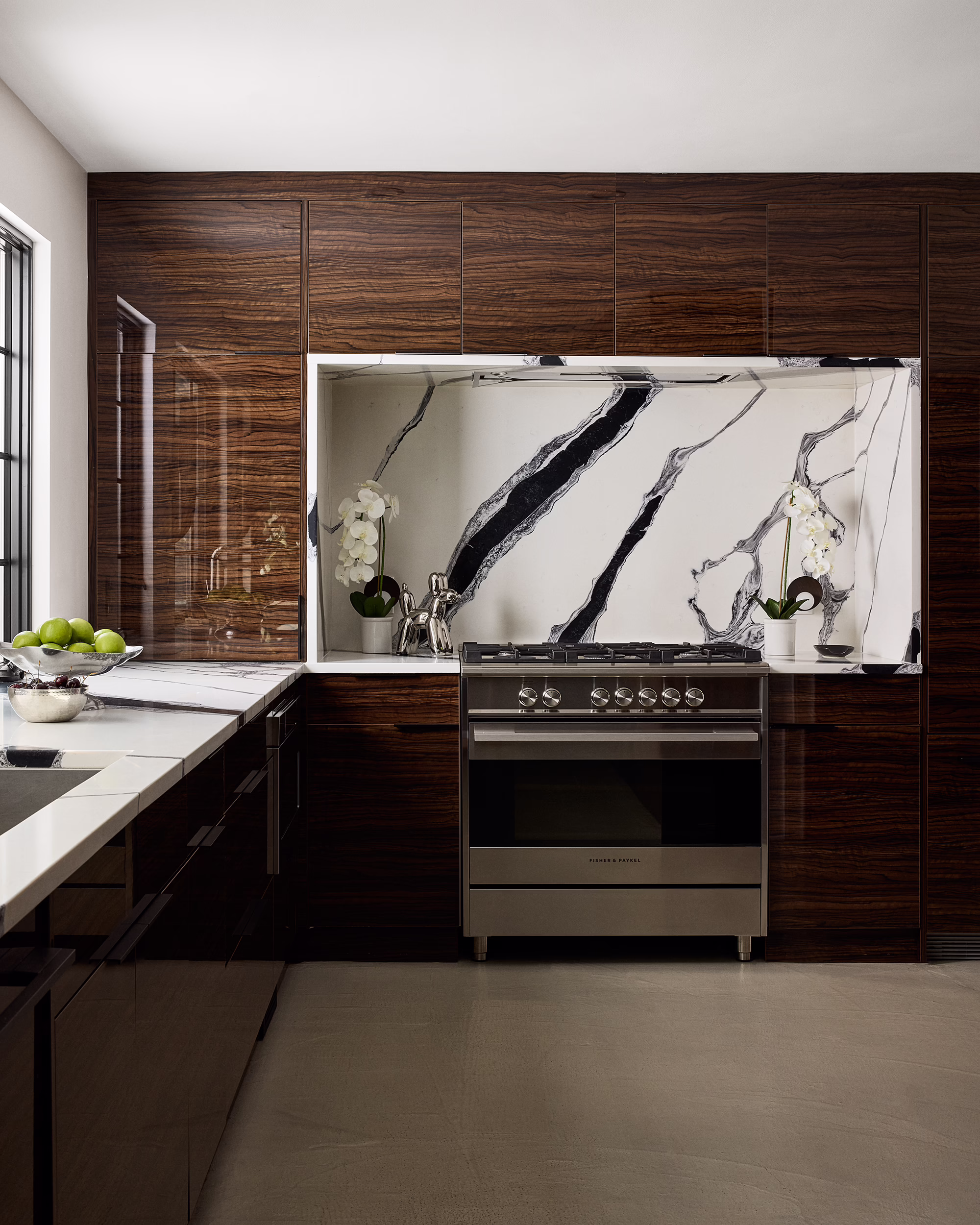 Crest kitchen with glossy dark wood cabinetry and a bold marble backsplash
